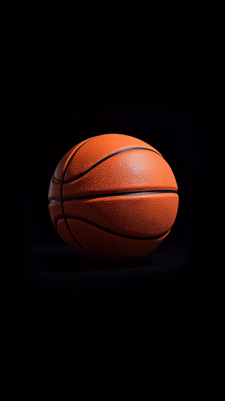 A basketball on a black background, highlighting its vibrant orange color and textured surface.