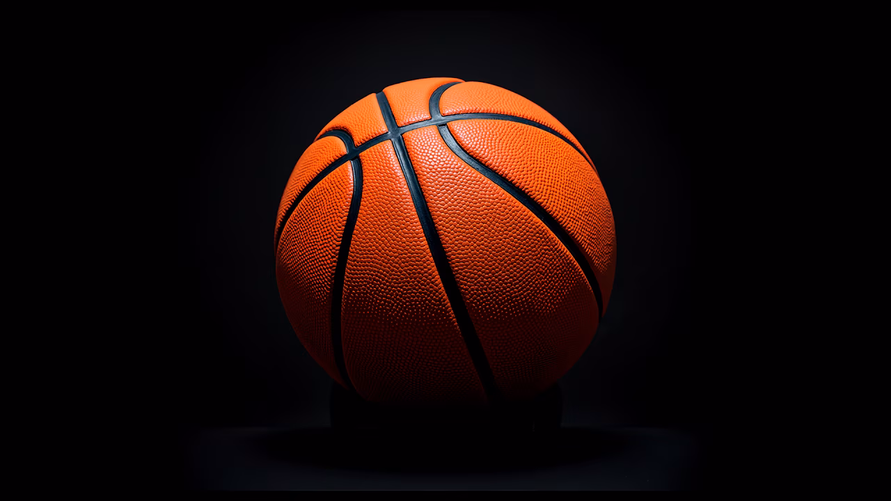 A basketball with vibrant orange color and textured surface, set against a dark background for dramatic effect.