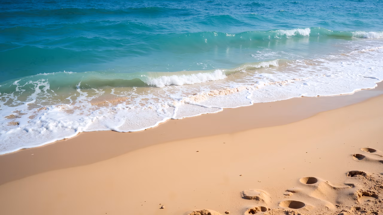 A tranquil beach scene with turquoise waves and sandy shores, perfect for relaxation and escape.