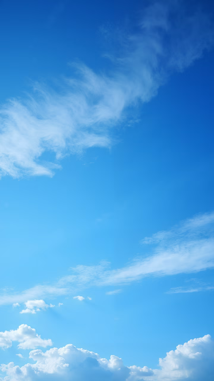 A serene sky filled with fluffy white clouds against a vibrant blue backdrop.