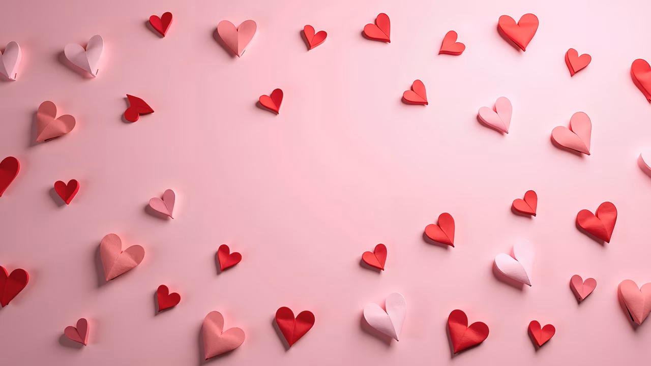 A heart pattern illustration with various shades of pink and red hearts on a soft pink background.