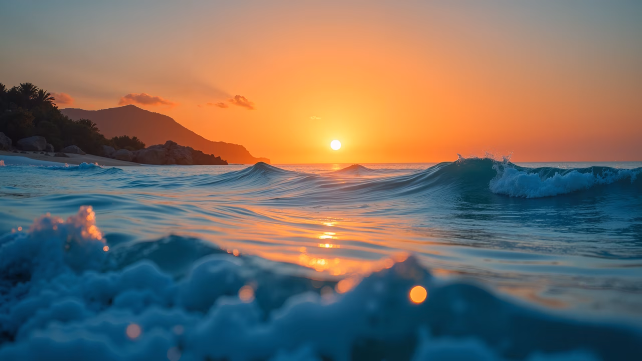 Vibrant ocean sunset with reflective water and gentle waves.