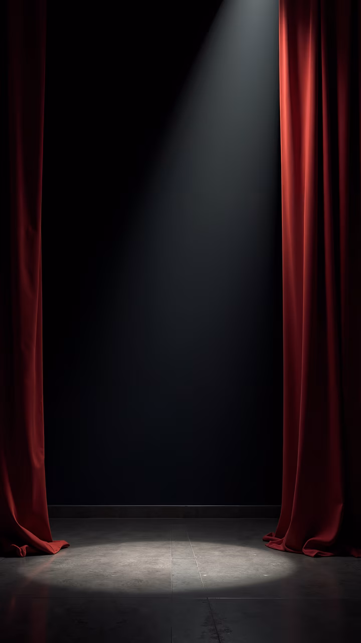 Red curtains and spotlight create a dramatic stage setting with high contrast and suspense.