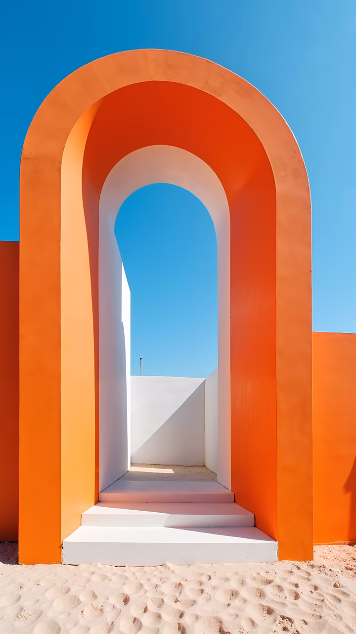 Vibrant archway with orange and white tones, set against a clear blue sky.