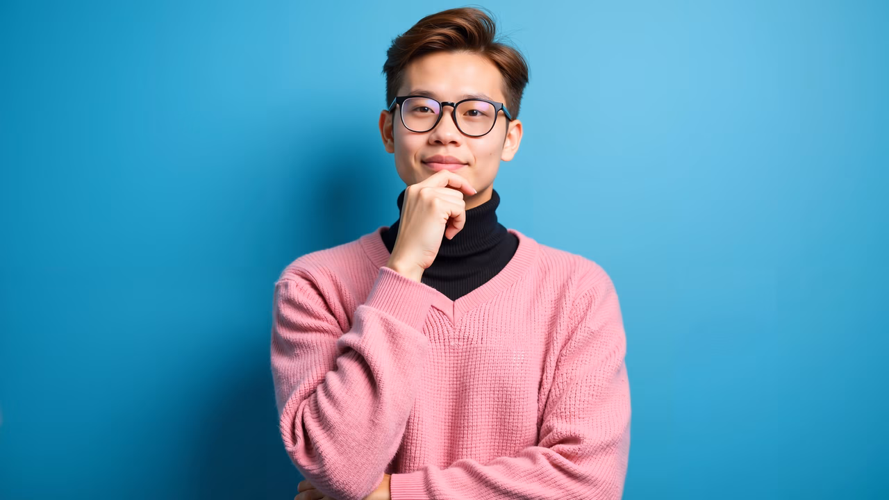 Thoughtful pose against a blue backdrop, capturing contemplation.