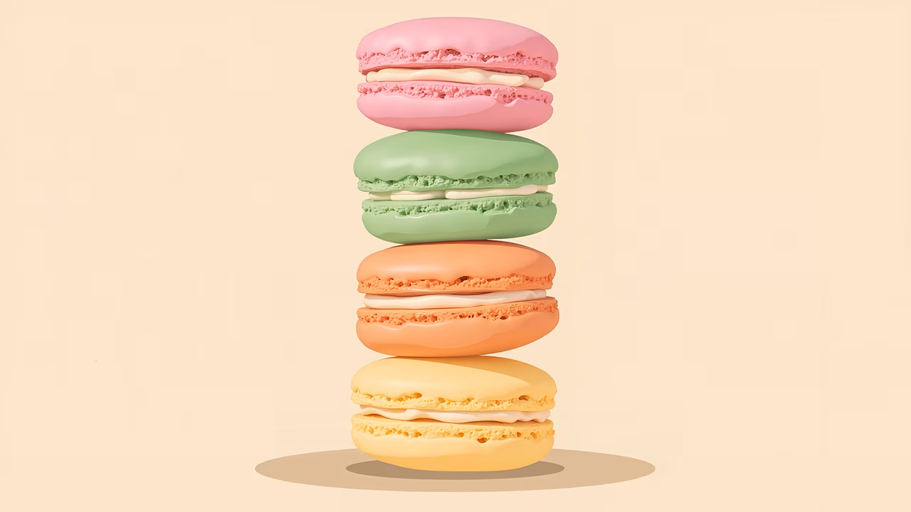 Delicate pastel macarons stacked beautifully on a neutral background.