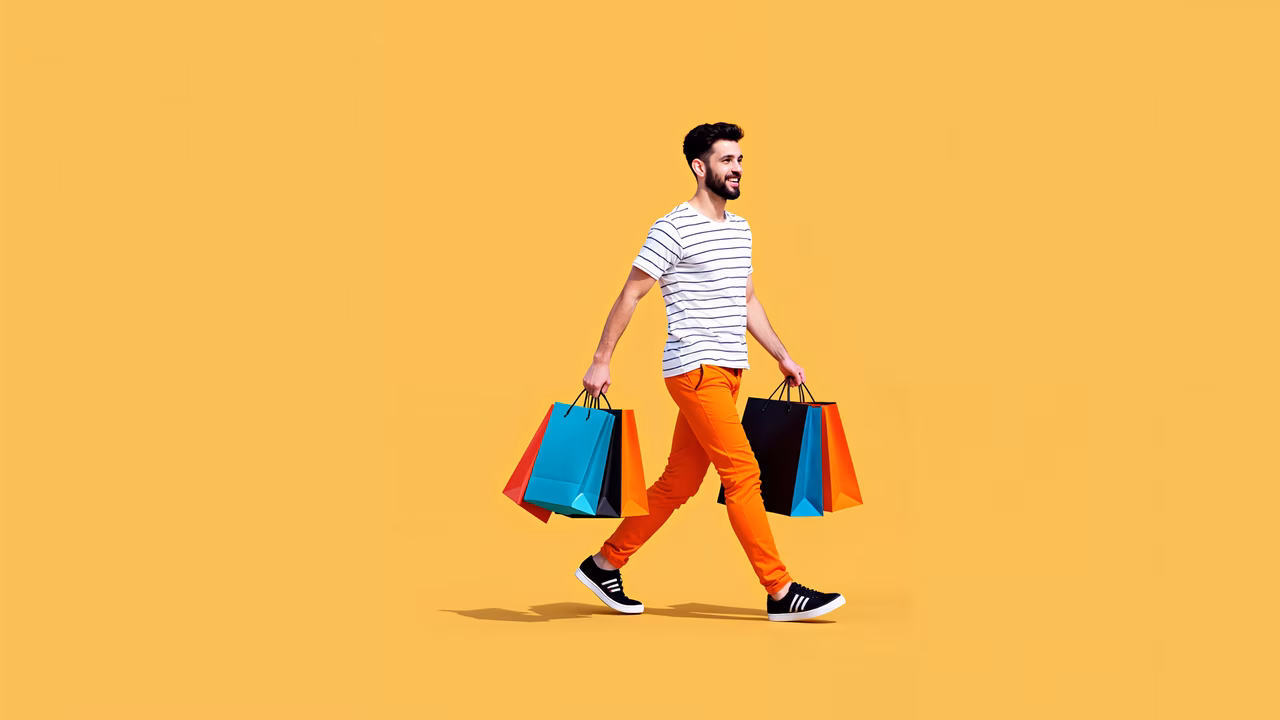 Brightly colored shopping bags carried by a stylish man against a vivid yellow background.