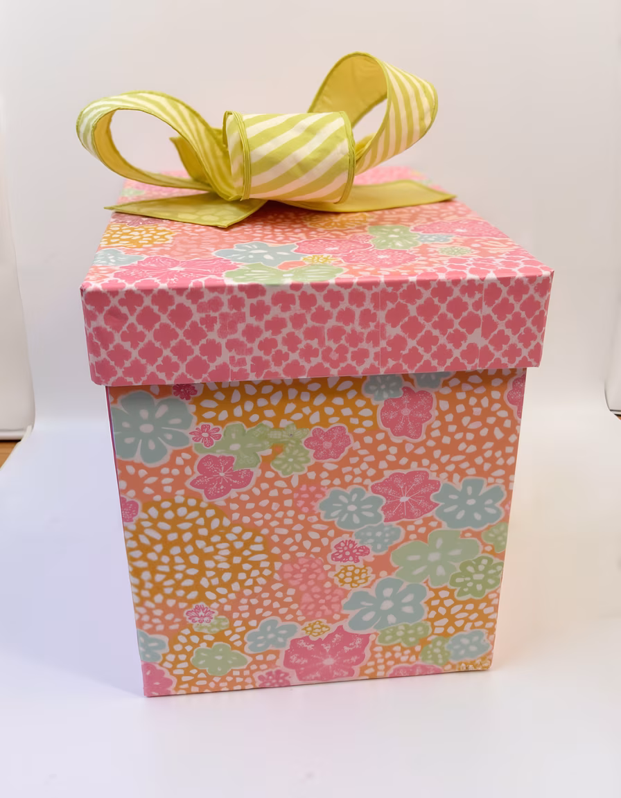 Brightly wrapped gift box with floral pattern on white background