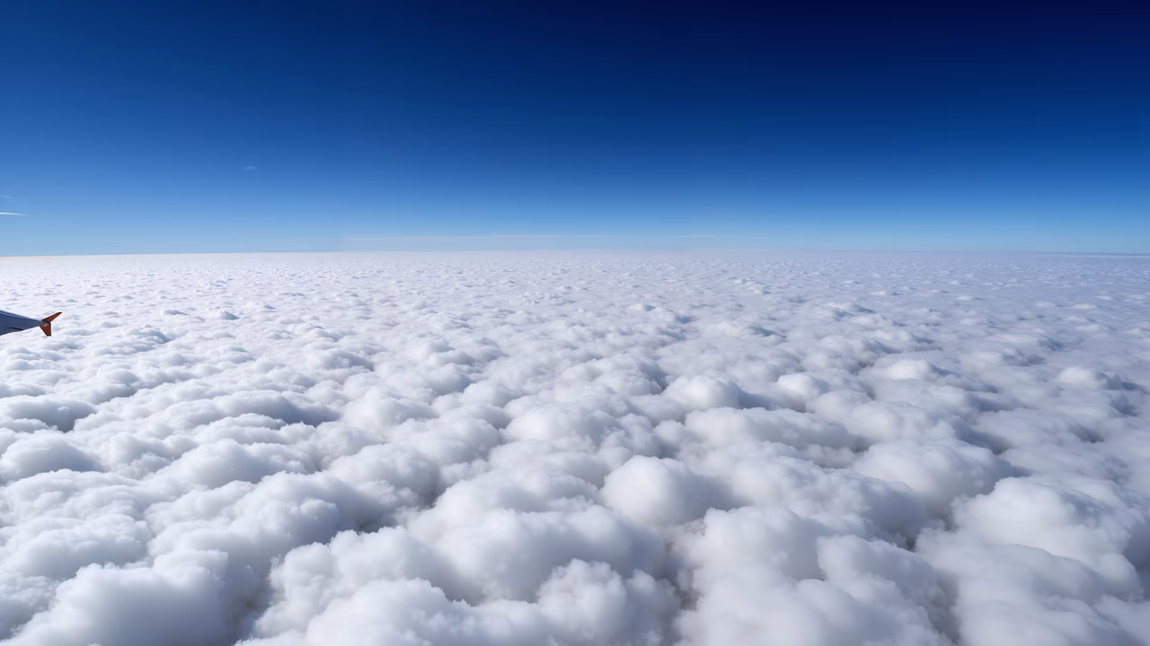 A serene aerial view of clouds against a clear blue sky.