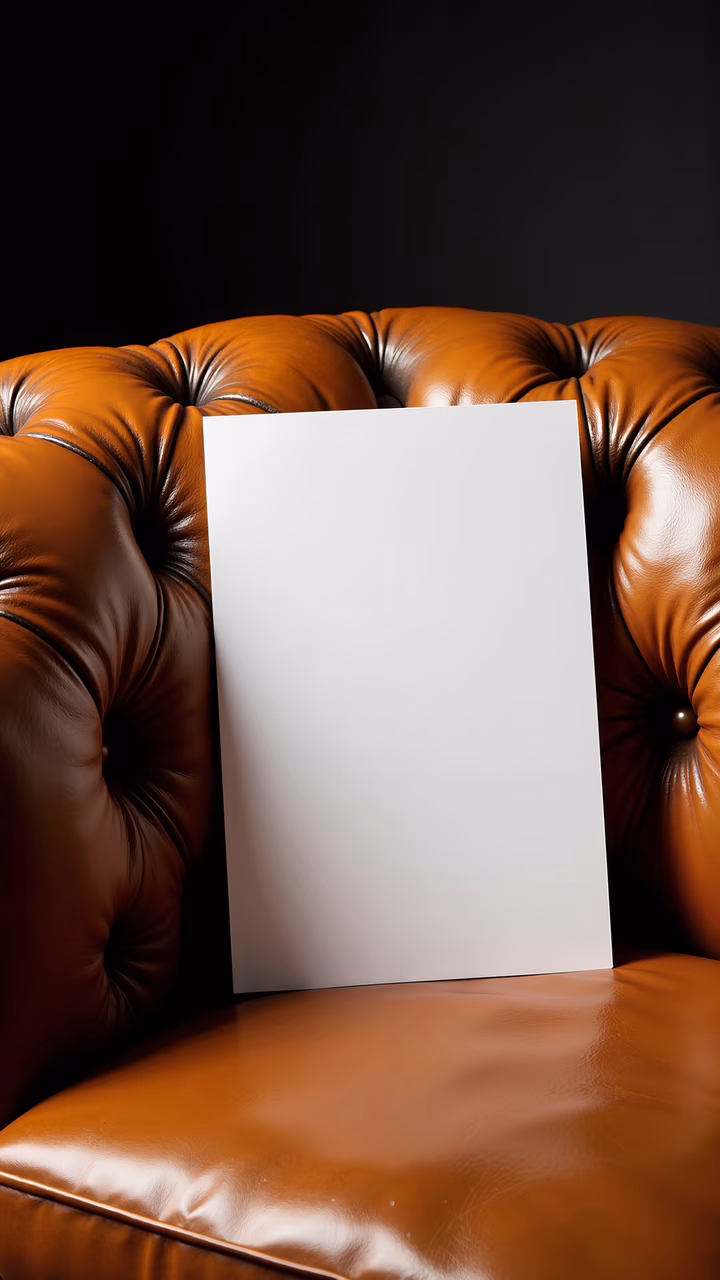 Close-up of a leather armchair with a blank canvas, contrasting textures and colors.