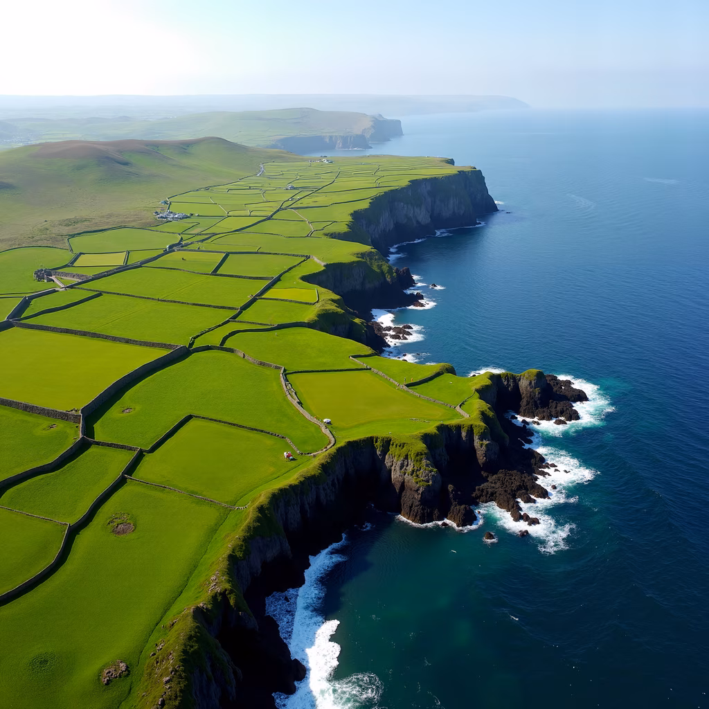 Aerial view of the Cliffs of Moher, Ireland, showcasing vibrant green fields and deep blue ocean.