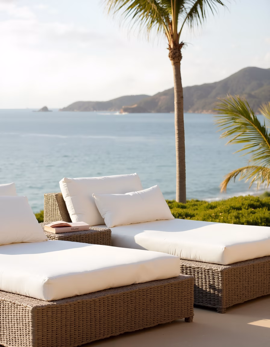 Relaxing coastal scene with chaise lounges and palm trees by the sea.