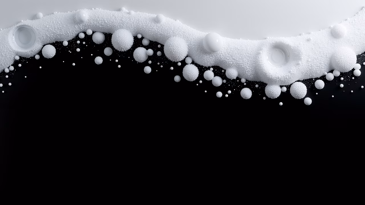Dynamic frothy bubbles bursting against a black background, creating a striking contrast.