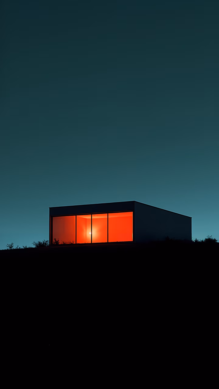 Minimalist house glowing warmly against a dark night sky, evoking tranquility.