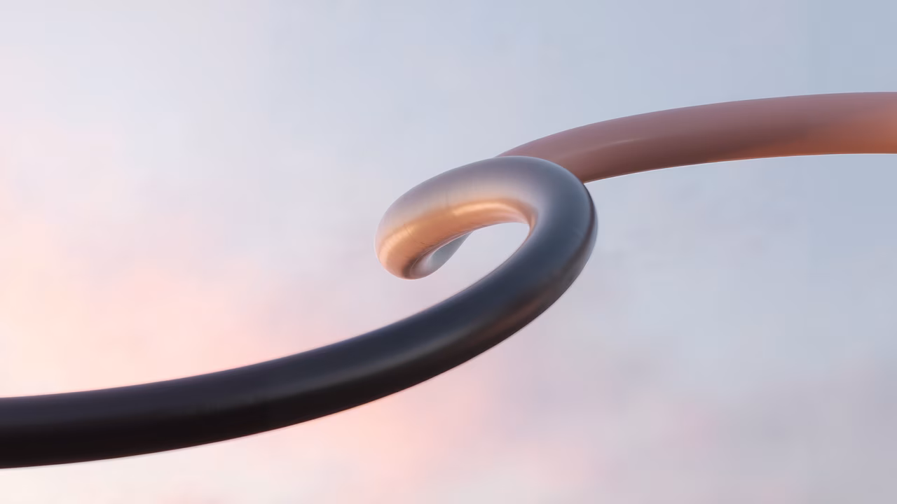 Abstract sculpture with metallic loop against pastel sky