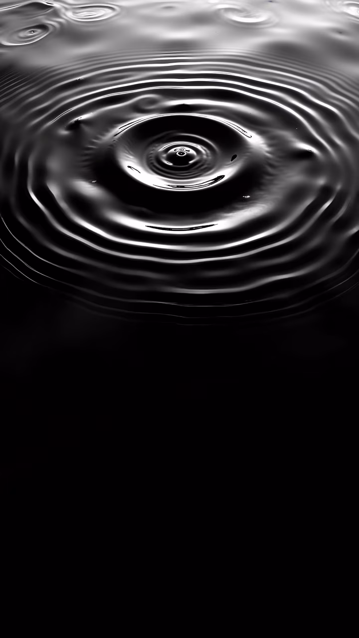 Monochrome close-up of water ripples, capturing the delicate interplay of light and shadow.