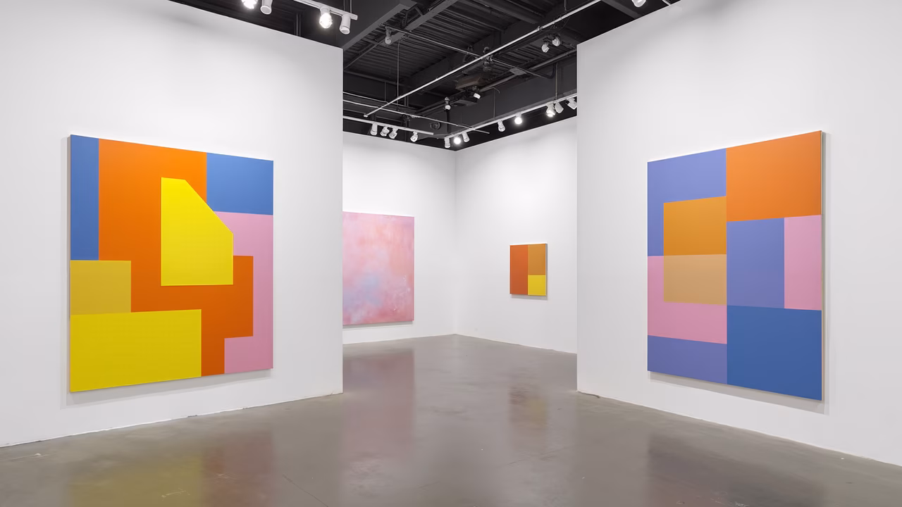 Vibrant abstract paintings in a modern gallery setting.