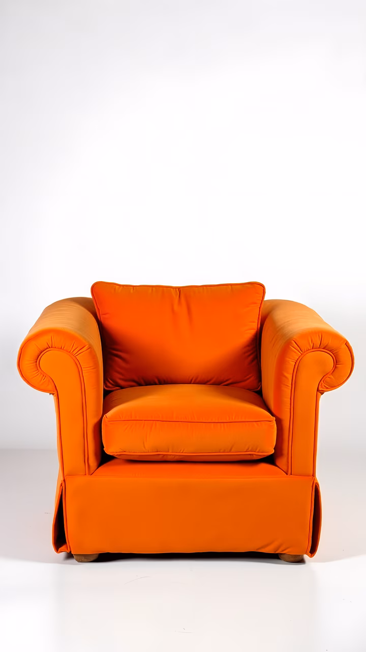 Bold orange armchair against a white backdrop, emphasizing comfort and elegance.