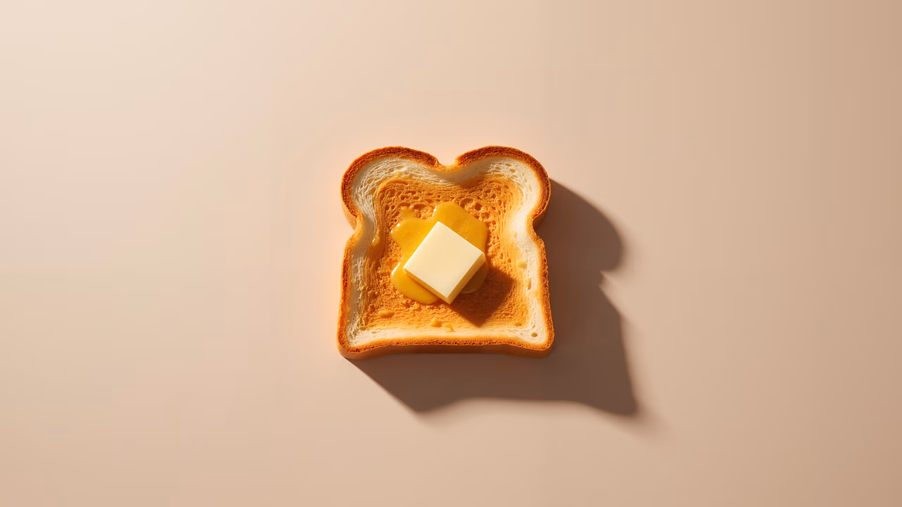 Golden toast with melting butter on a soft background.