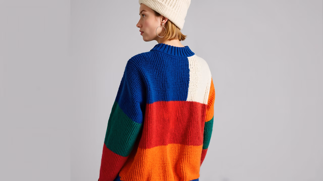 Bold, colorful sweater with geometric patterns and chunky knit texture.
