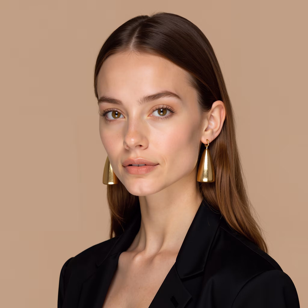Elegant gold earrings paired with a chic black blazer on a neutral background.