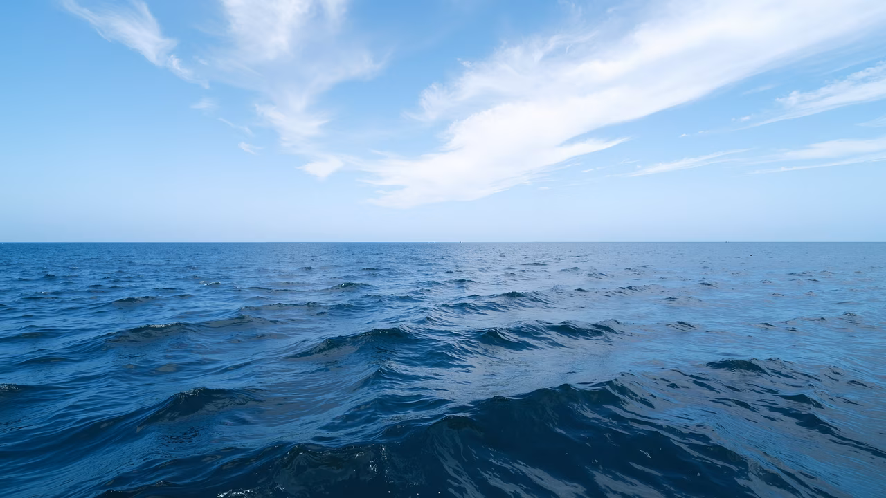 A peaceful ocean vista under a bright blue sky.