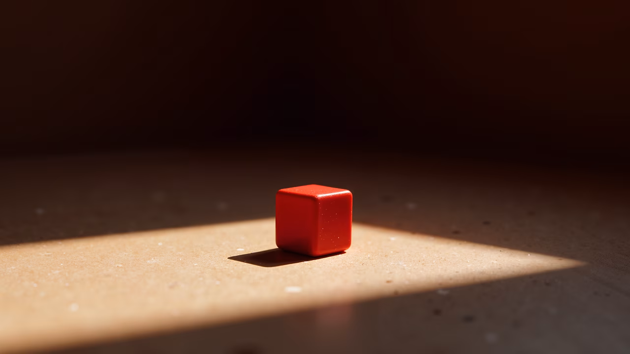 A minimalist photograph featuring a red cube in sunlight, evoking calmness and simplicity.