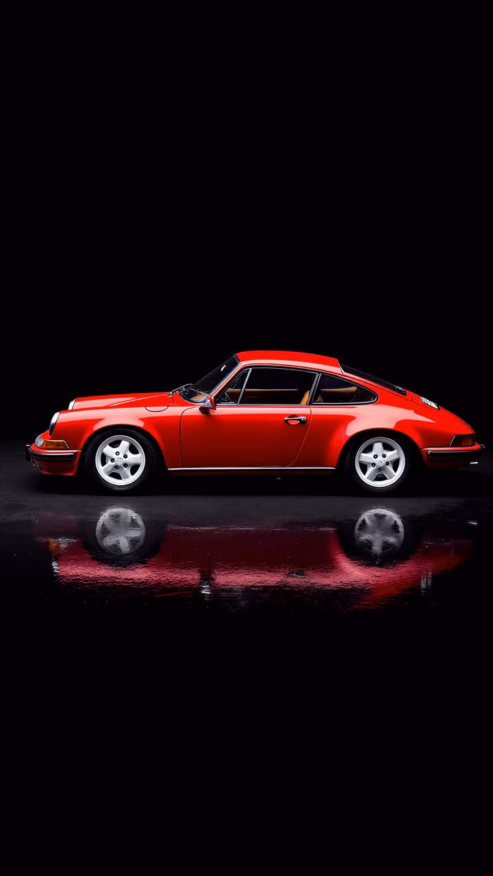 Classic red Porsche reflected in a glossy surface, automotive elegance.