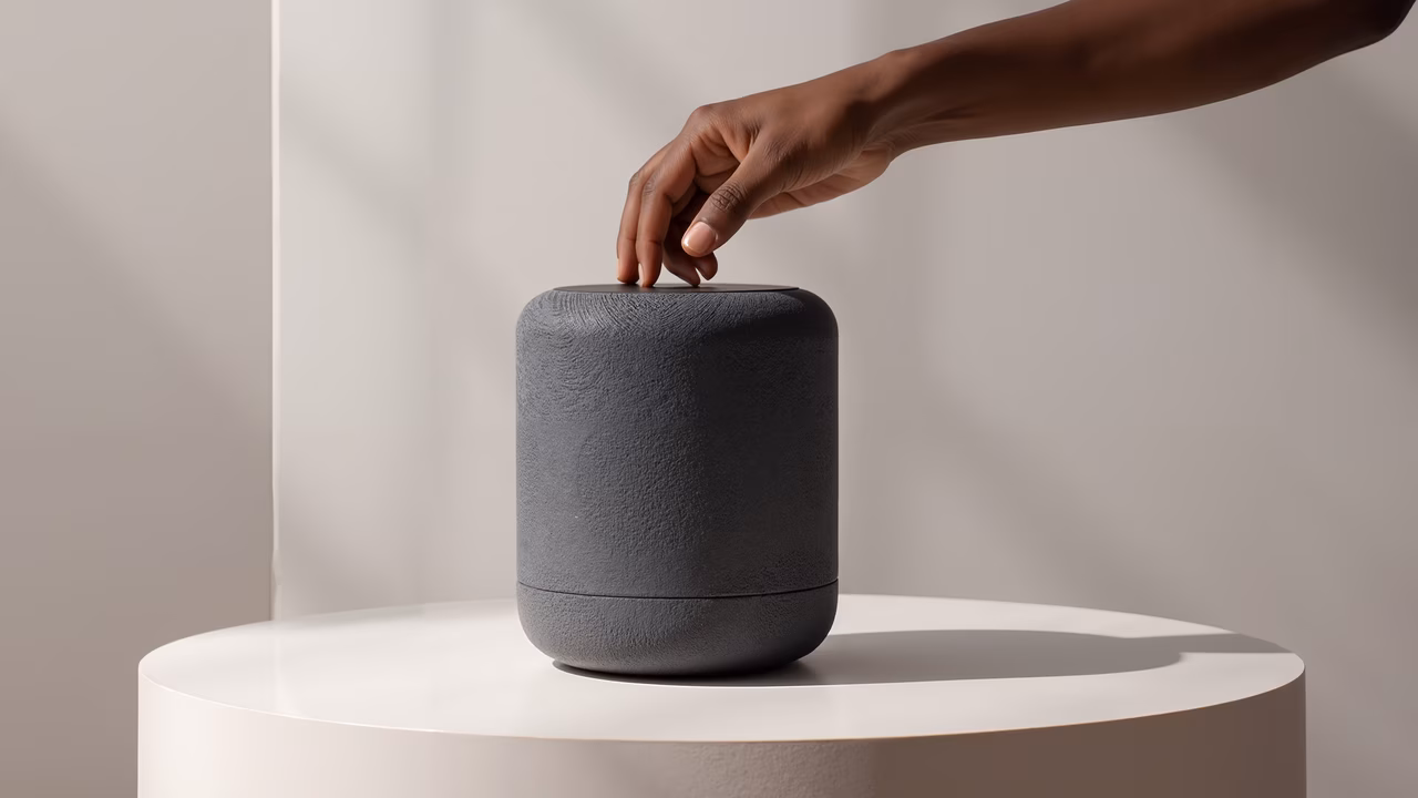 Minimalist shot of a hand interacting with a sleek speaker.