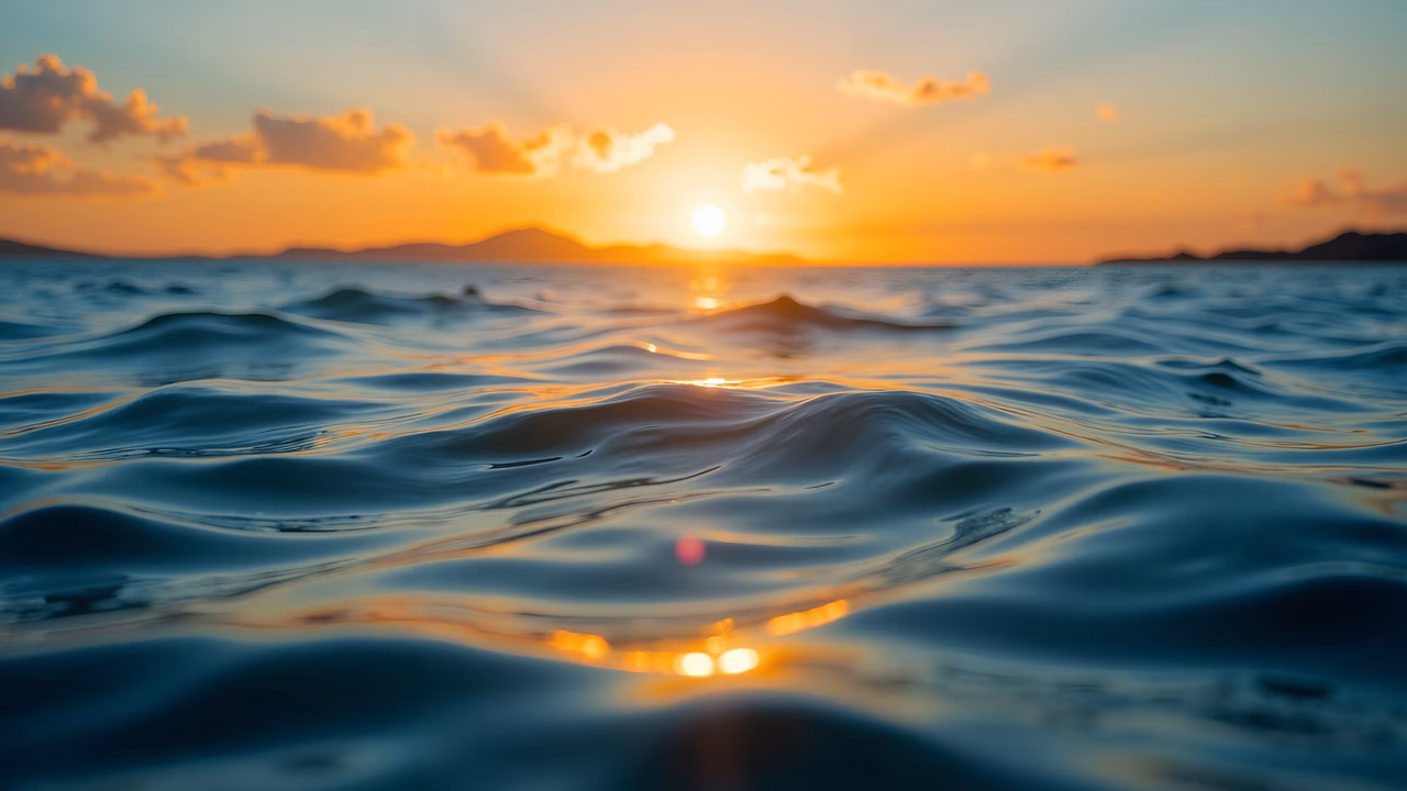 A breathtaking ocean sunset with warm colors and rippling water.