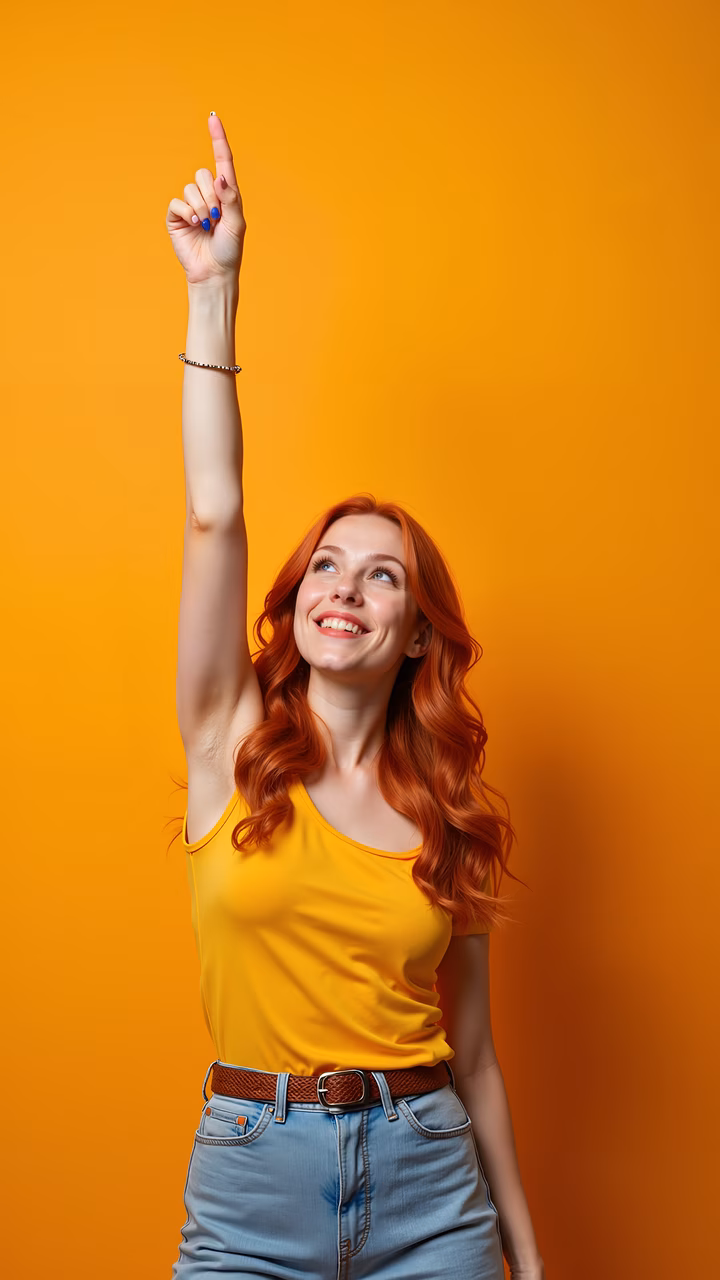 Enthusiastic woman pointing up against a warm orange background.