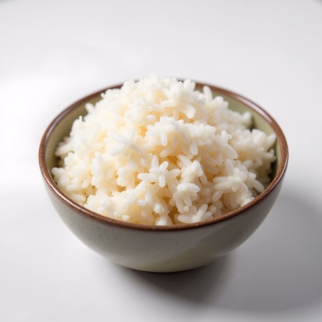 Close-up of steamed rice in a bowl, emphasizing texture and freshness.