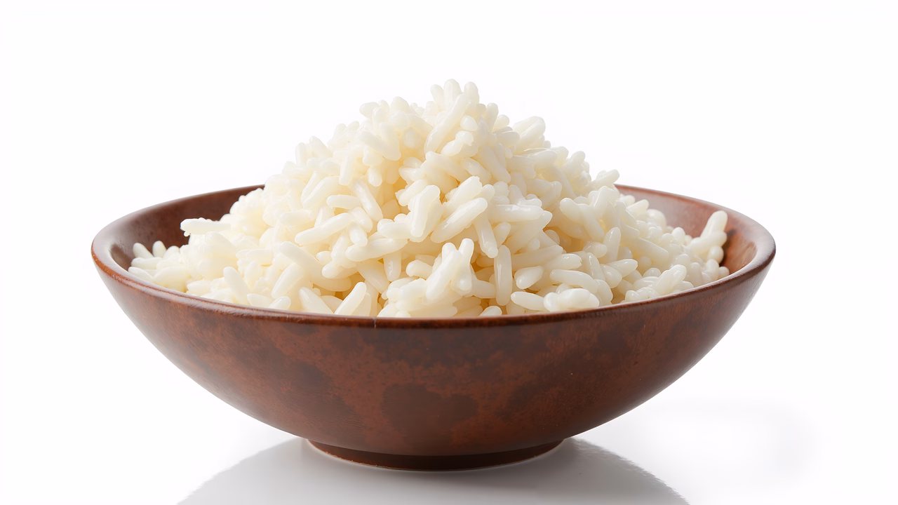 Close-up of fluffy white rice in a brown bowl on a white background.