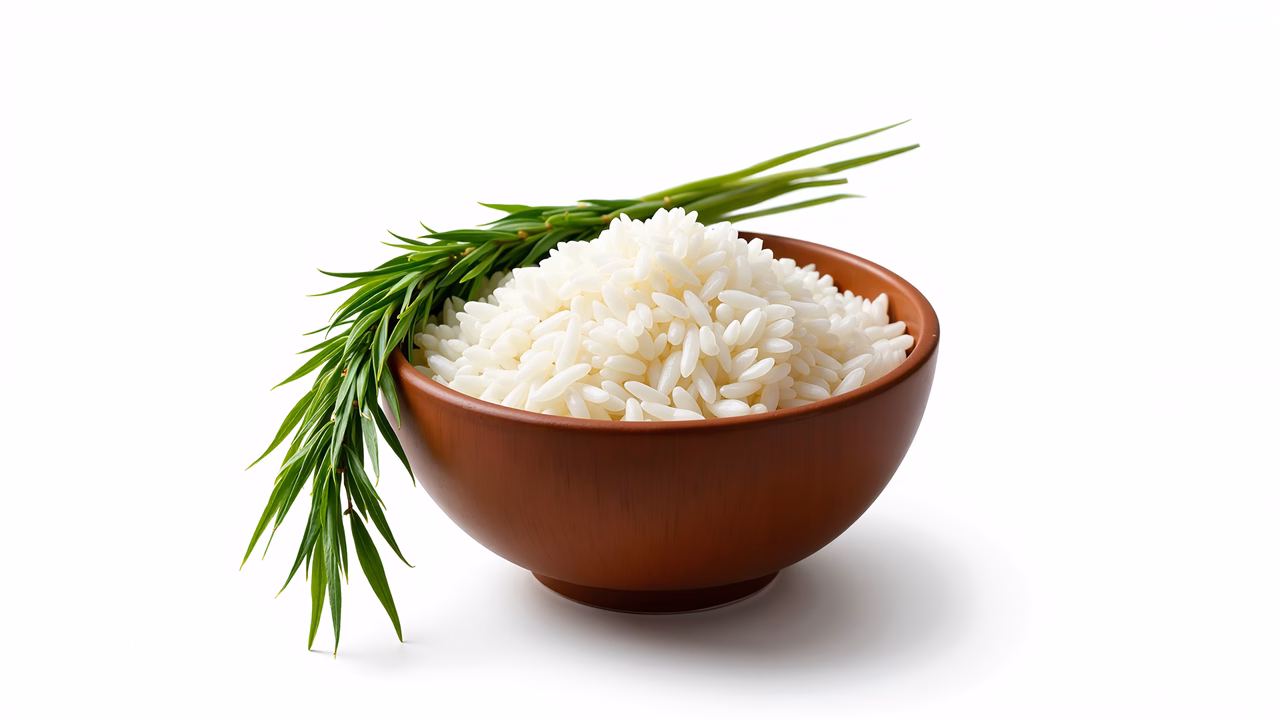 Close-up photo of rice in a bowl with green herb sprigs.