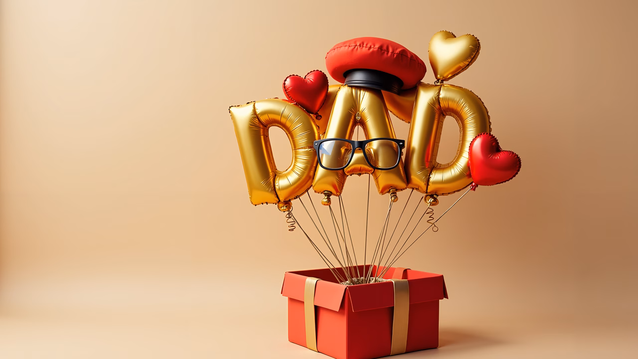 Golden balloons spell 'DAD' over a red gift box for a festive Father's Day tribute.