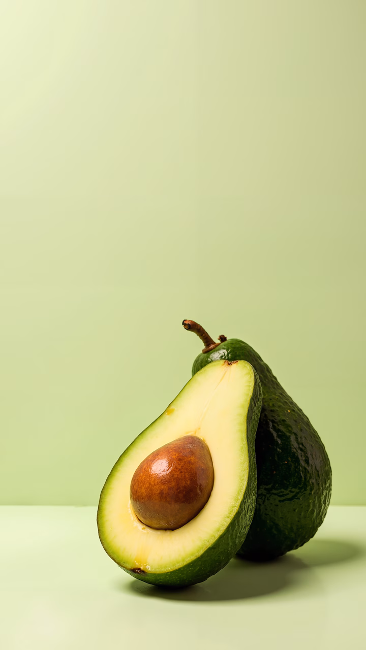 Close-up of halved avocado against a green backdrop, emphasizing freshness and natural beauty.