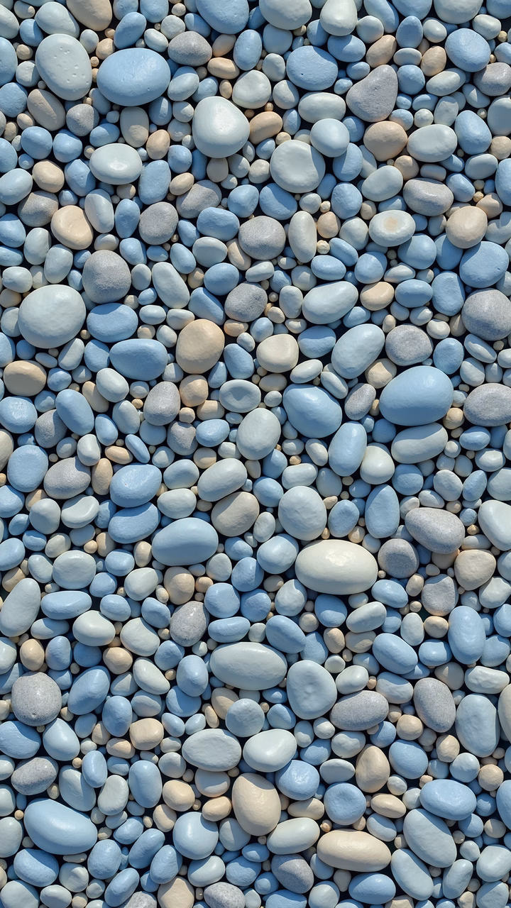Close-up of blue and beige pebbles on a flat surface, showcasing their varied textures and colors.