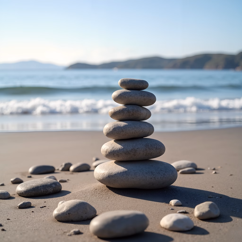 A tranquil beach scene with stacked stones and rolling waves.