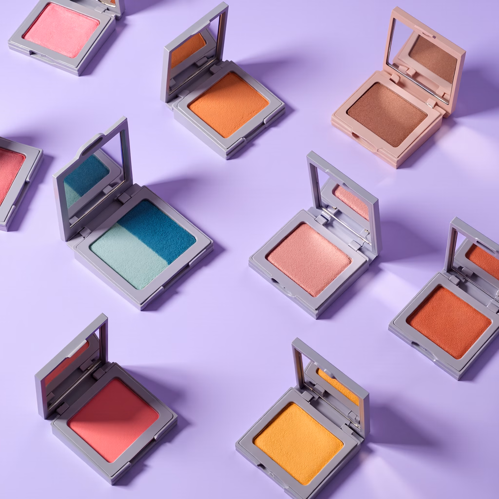 Vibrant eyeshadow palettes on a purple background.