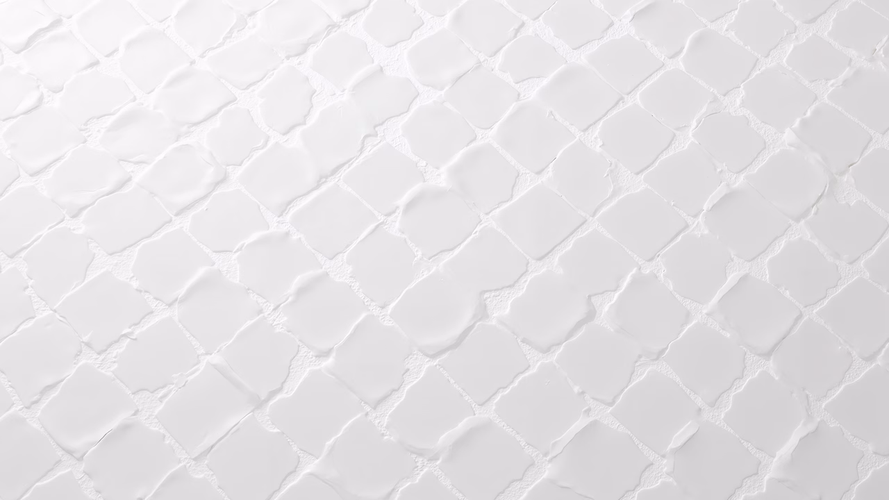 Monochromatic white tiles with subtle textural variations.