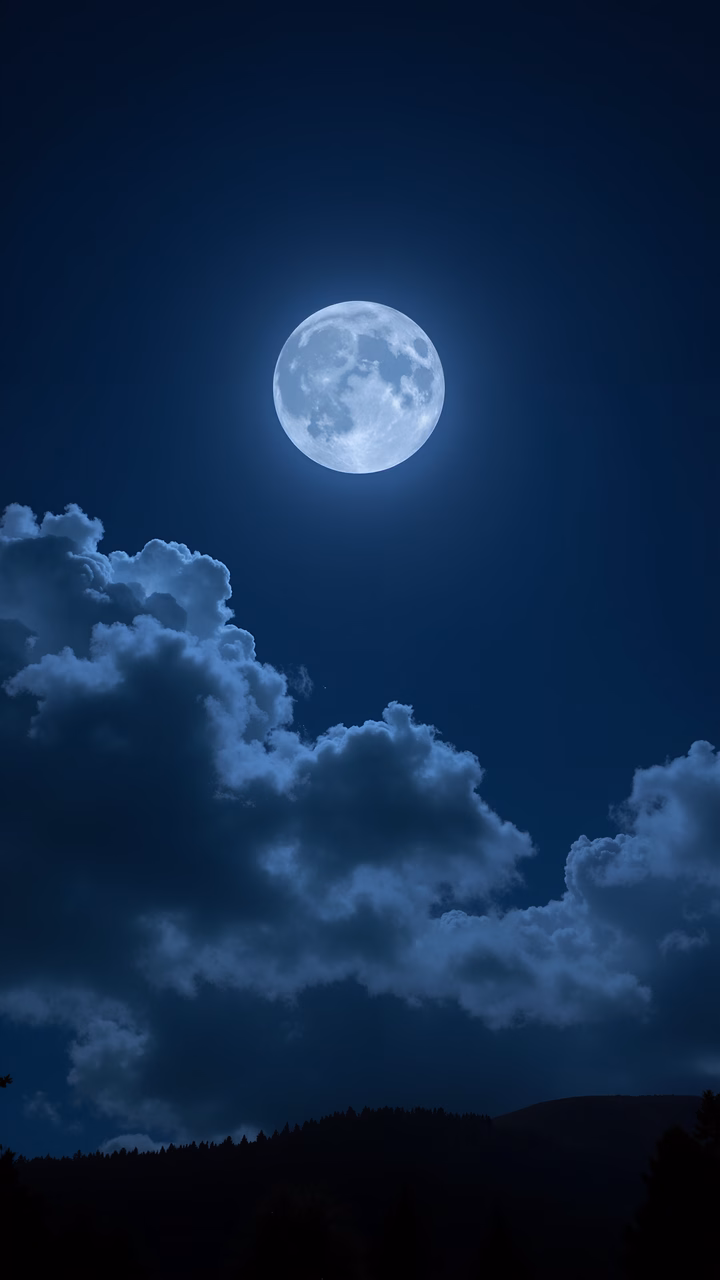 A full moon illuminates a night sky filled with clouds, evoking a sense of peace and wonder.