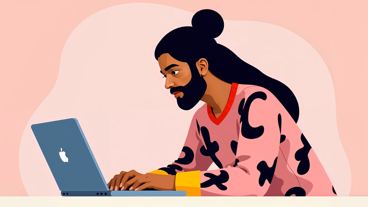 A focused man working on a laptop against a soft pink backdrop.