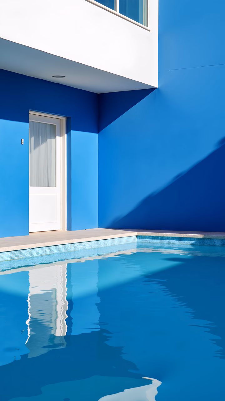 Bold blue architecture reflected in a serene pool, capturing tranquility and symmetry.