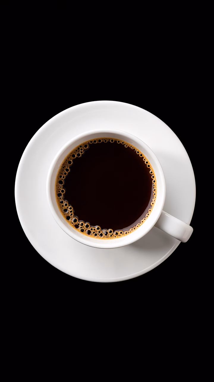 Close-up of steaming espresso cup on white saucer.