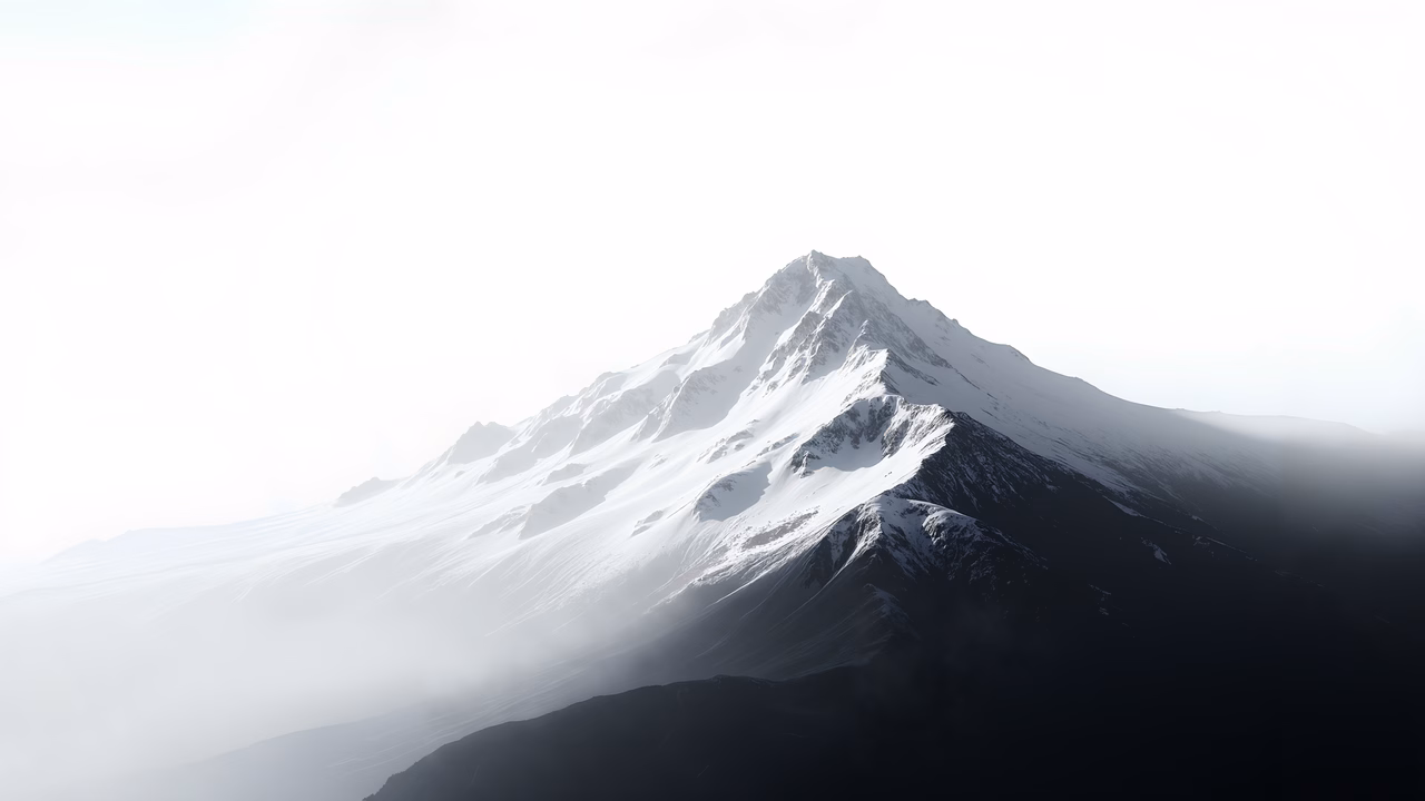Snowy mountain peak amidst foggy landscape