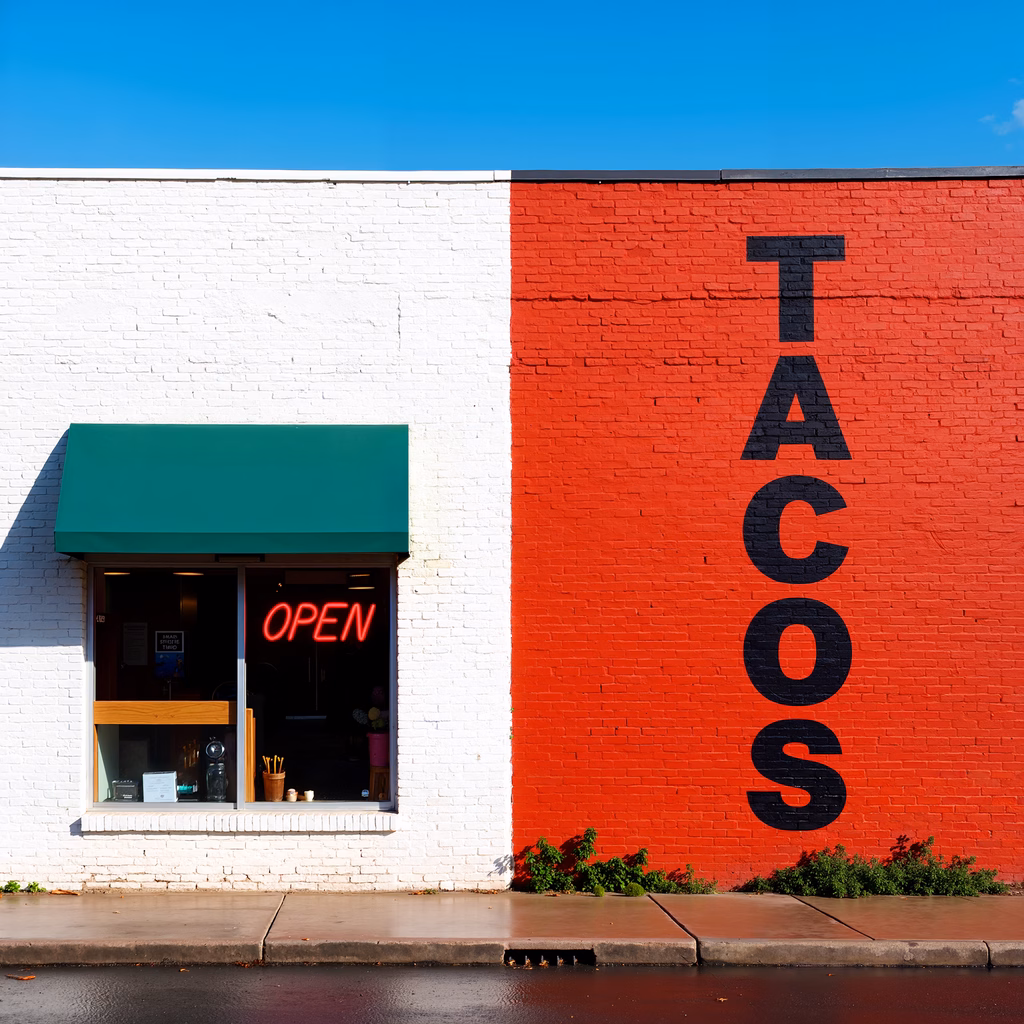 Bold red brick wall with 'TACOS' neon sign and 'OPEN' glowing neon in a sunny urban setting.