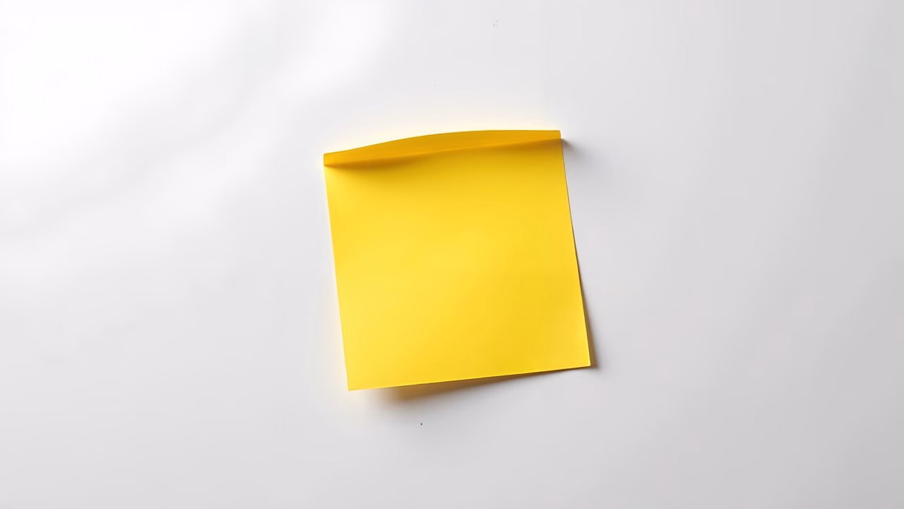 Bright yellow sticky note on white background