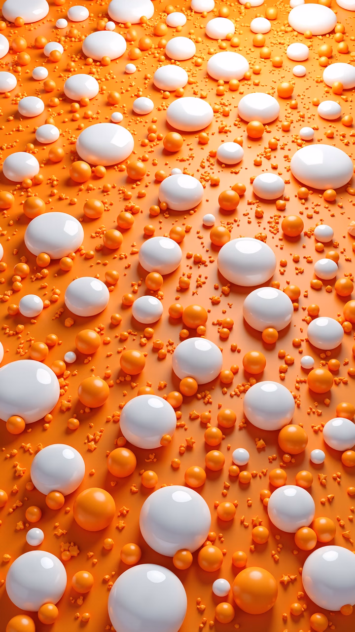 Glossy spheres in vibrant orange and white hues create a dynamic abstract illustration.