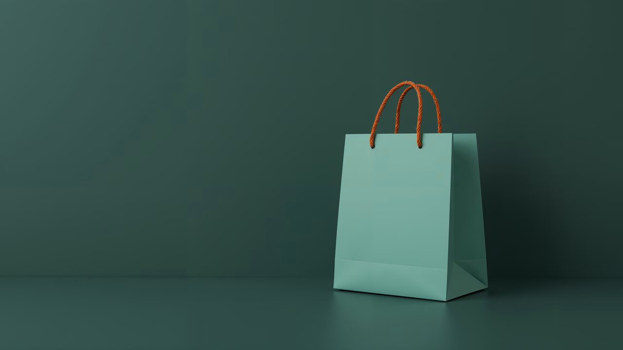 Minimalist shopping bag with teal body and orange handles on a dark green background.