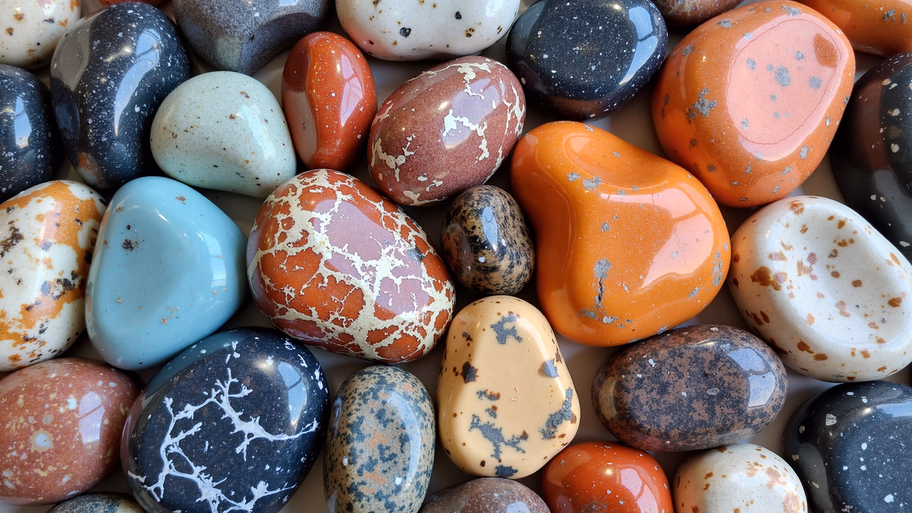 Close-up of colorful, speckled stones with glossy finishes and vibrant hues.